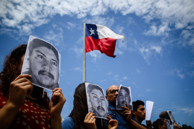 Jóvenes protestan en silencio con la cara de Catrillanca frente a La Moneda