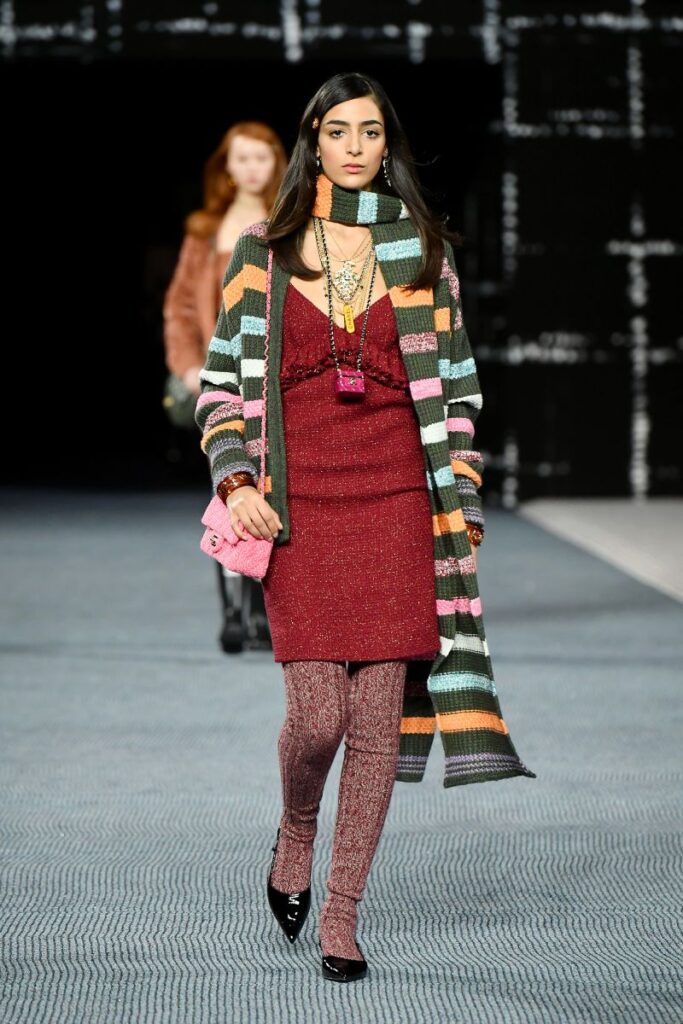 Una modelo desfila en el desfile Otoño/Invierno 2023 de Chanel con un vestido a capas con medias gruesas y una bufanda de punto. Dominique Charriau/WireImage/Getty Images vía CNN Newsource
