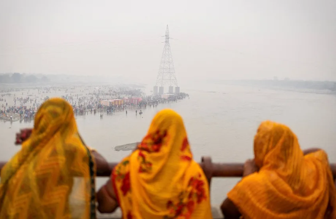 Los devotos hindúes adoran al dios Sol en las orillas del río Yamuna en una mañana brumosa en Noida el 28 de octubre de 2025. Adnan Abidi/Reuters