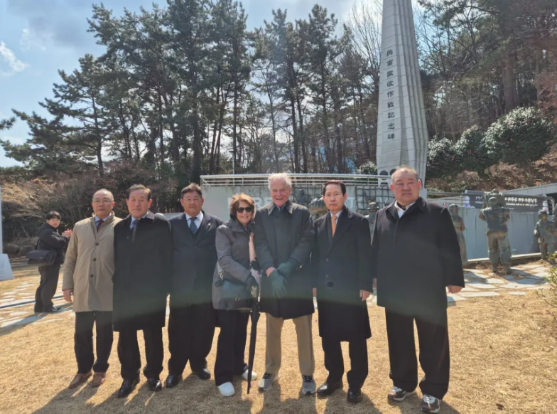 Burley Smith (centro), el último miembro vivo de la tripulación del SS Meredith Victory, se reunió con Kimchi 1 (segundo desde la derecha) y Kimchi 5 (segundo desde la izquierda) en la ceremonia conmemorativa de la evacuación de Hungnam en marzo de 2025 en la isla de Geoje, Corea del Sur. Burley Smith