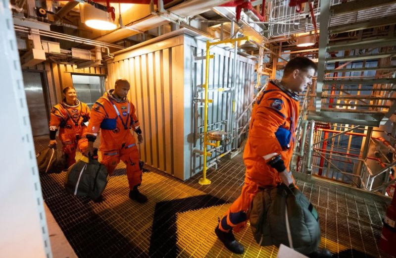 (de izquierda a derecha) Christina Koch y Victor Glover, de la NASA, y Jeremy Hansen, de la Agencia Espacial Canadiense, caminan hacia el brazo de acceso de la tripulación. Joel Kowsky/NASA